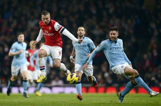 Arsenal's Lukas Podolski (L) vies with City's Matija Nastasic (R) in London on January 13, 2013
